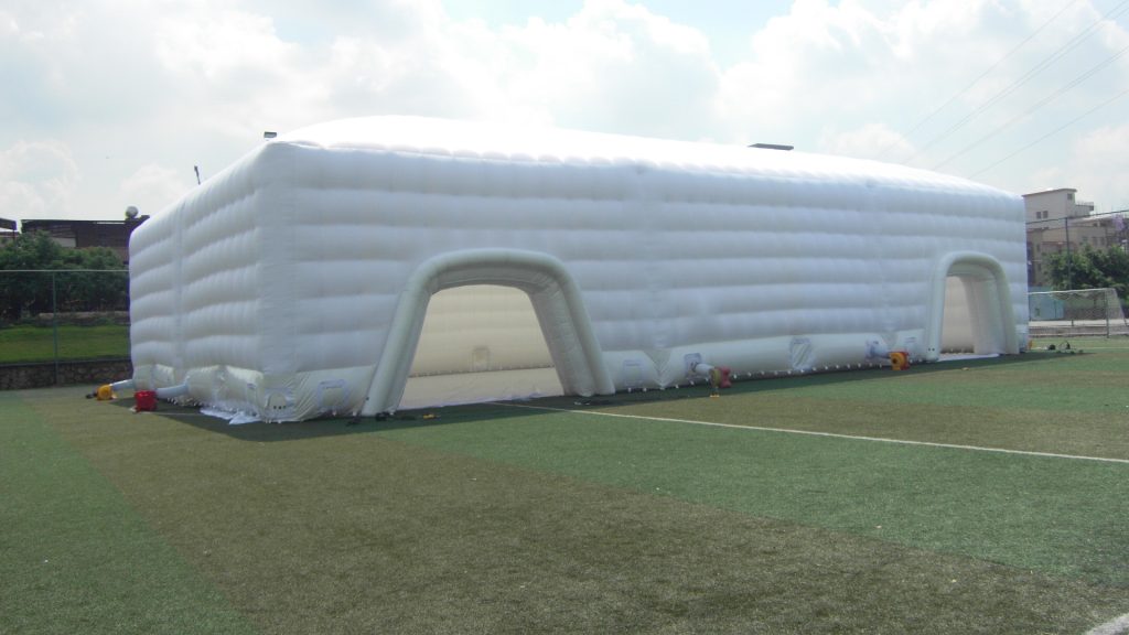 Grote witte opblaasbare tent op een sportveld