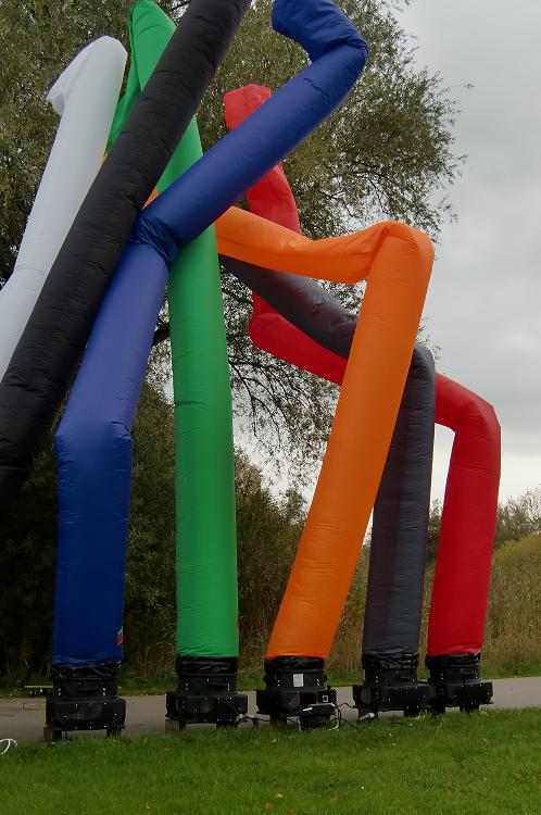 Verschillende gekleurde opblaasbare skytubes met blowers op een grasveld