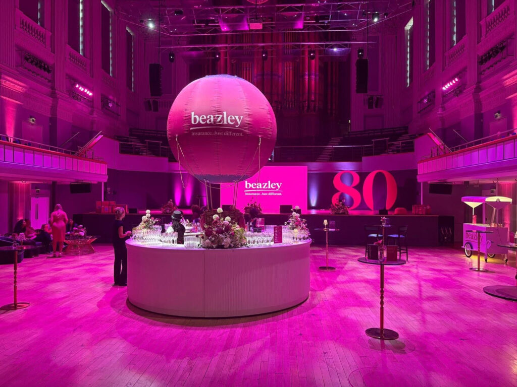 Roze opblaasbare reclameballon met logo boven de bar tijdens een bedrijfsevenement