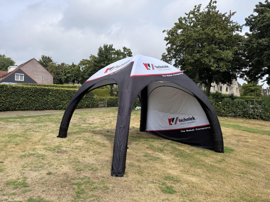 Opblaasbare tent met bedrukte zijwand en een binnentent op een grasveld