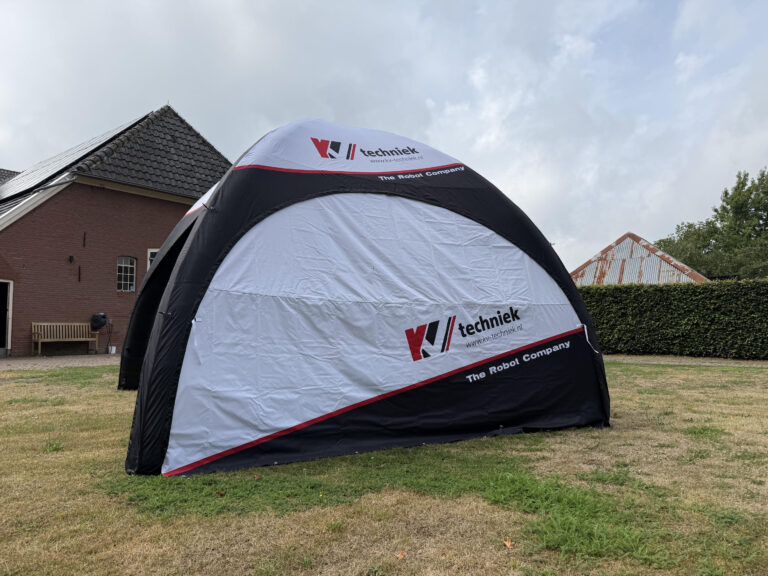 Opblaasbare tent met gesloten bedrukte zijwanden op een grasveld