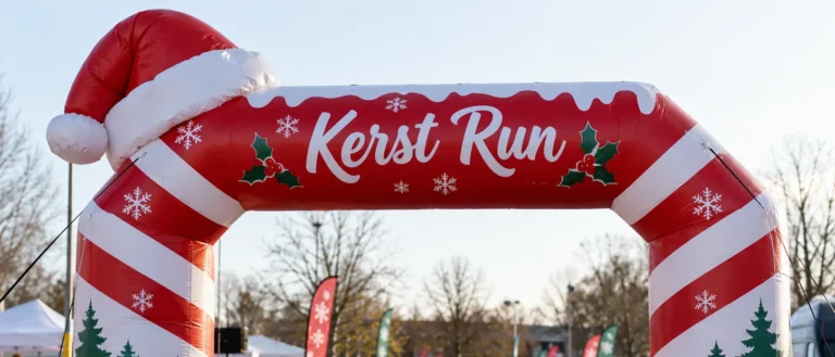 Opblaasbare boog in kerstthema met de tekst Kerst Run bij een winterevenement